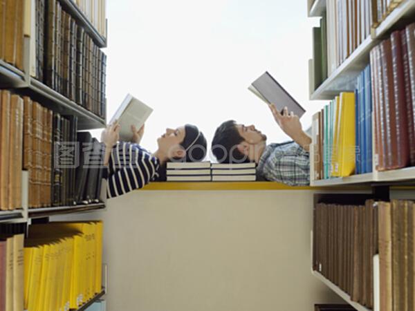 在图书馆读书时,男女学生躺在窗台上
